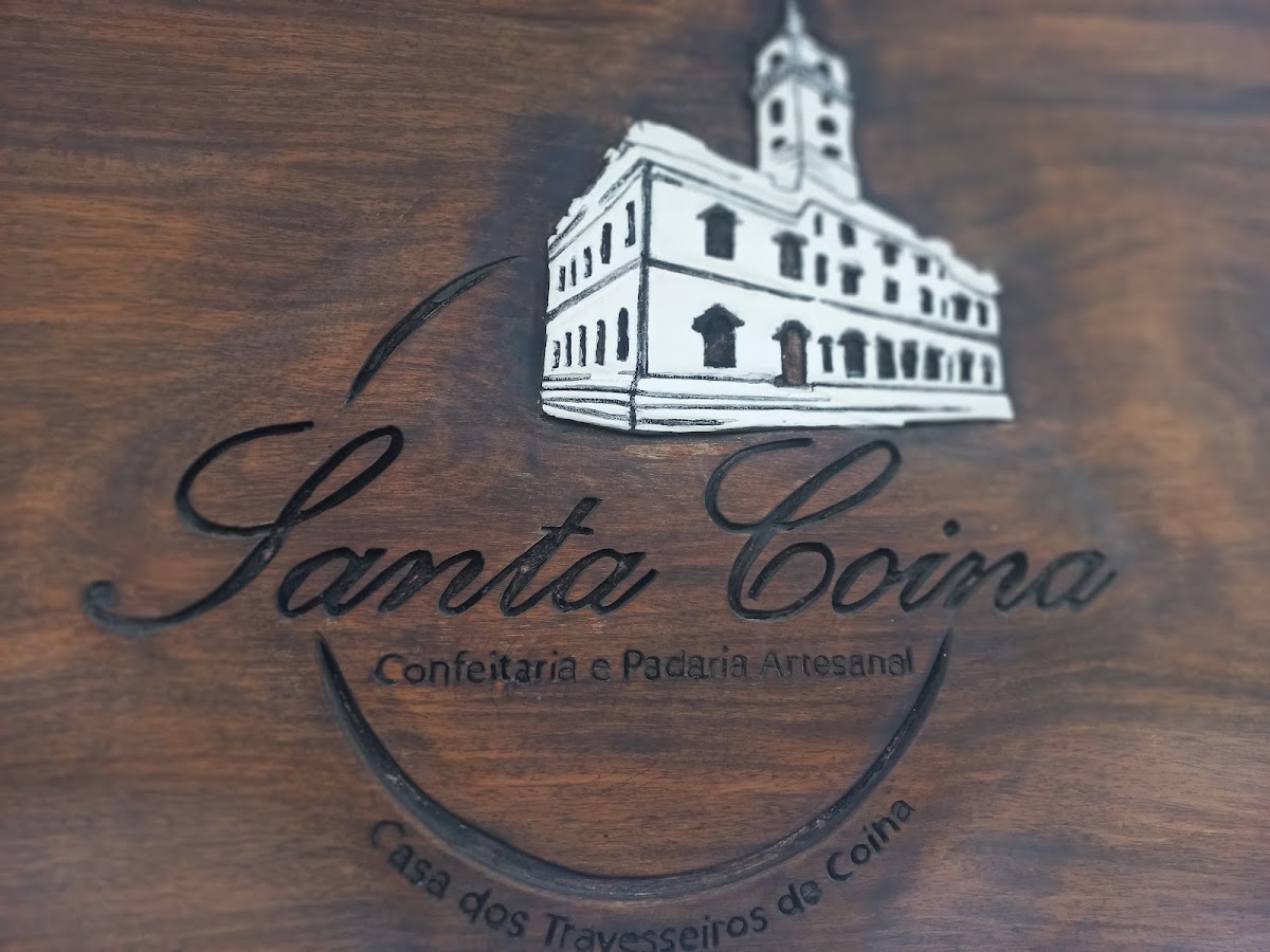 O logótipo Santa Coina esculpido em madeira de nogueira, com o desenho do antigo edifício de Coina